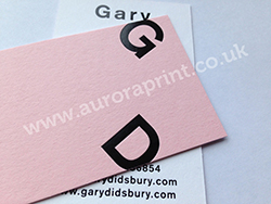 Gloss black foil printed business cards on candy pink colorplan